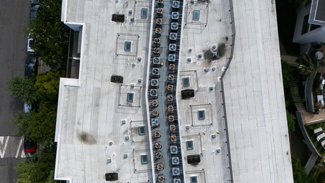 Aerial view of a flat building roof with a central row of HVAC units and skylights, near South San Vicente Boulevard and South Fairfax Avenue in Los Angeles, California, United States.