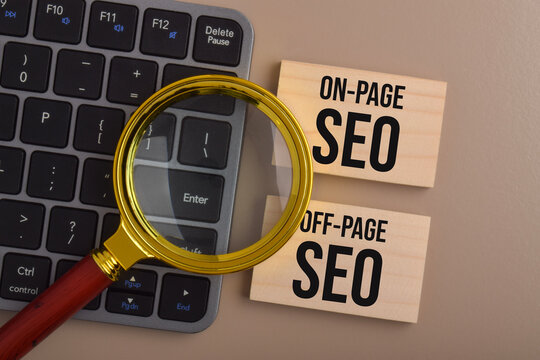 Magnifying glass over a laptop keyboard beside wooden blocks labeled on-page SEO and off-page SEO, representing website optimization and digital marketing strategies.