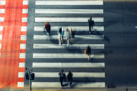 Aerial view of people walking across a zebra crossing with red road markings in Poland.