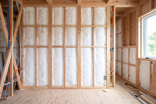 木造軸組と断熱材が見える新築一戸建て住宅の内装工事現場