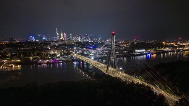 Aerial view of the illuminated Warsaw skyline and the Swietokrzyski Bridge over the Vistula River at night in Warsaw, Masovian Voivodeship, Poland.
