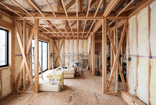木造軸組と断熱材が見える新築一戸建て住宅の内装工事現場