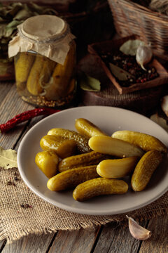 Homemade canned gherkins on a rustic wooden background.