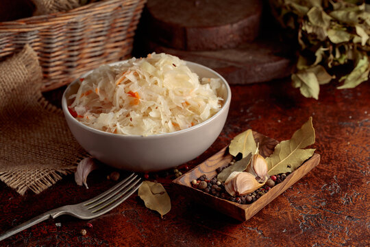 Sauerkraut with ingredients on a rustic background.