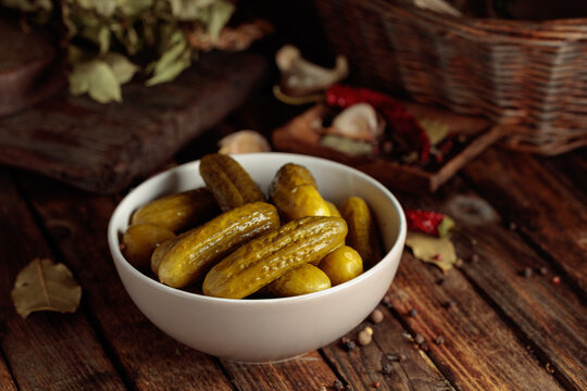 Homemade canned gherkins on a rustic wooden background.