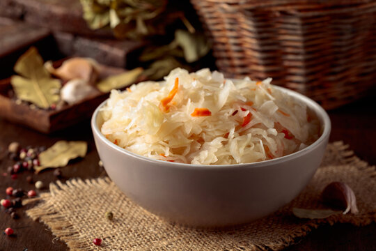 Homemade sauerkraut with carrot on an old wooden table.
