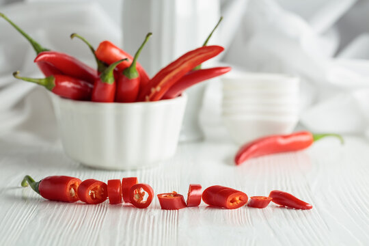 Fresh red chili peppers with on a white wooden table.