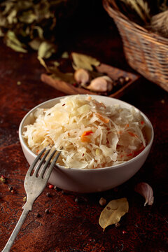 Sauerkraut with ingredients on a rustic background.