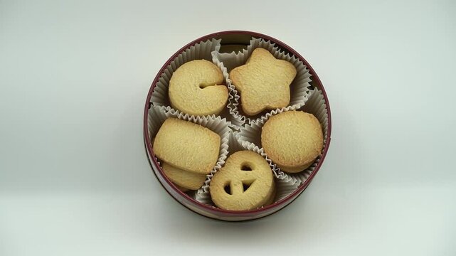 Traditional Danish butter cookies assorted in a round metal tin isolated on a white background