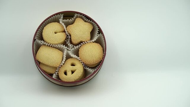 Traditional Danish butter cookies assorted in a round metal tin isolated on a white background