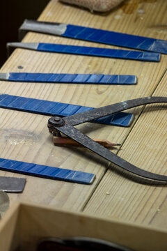 Wooden workbench with a metal compass tool pencil and rows of blue glazed ceramic tile samples, Kyushu region, Arita, Japan