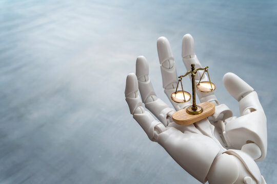 White robotic hand holding a scale of justice. AI in law, legal technology, algorithmic bias, robot ethics concept.