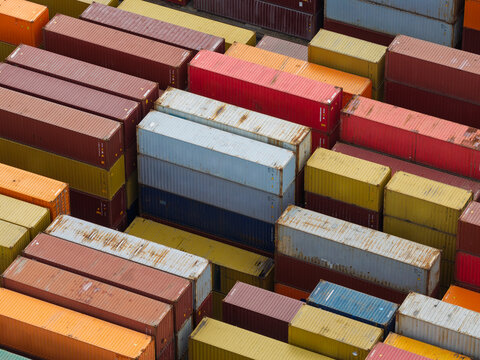 Aerial view of colorful shipping containers stacked in a busy port terminal in the United Kingdom.