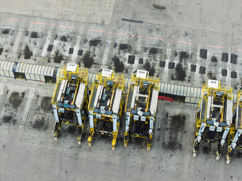 Aerial view of yellow straddle carriers parked in a row at a container terminal in the United Kingdom.