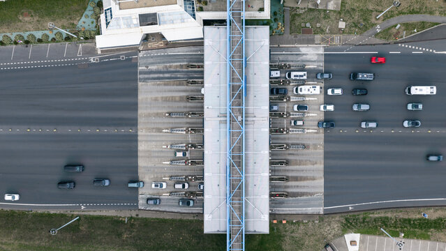 Aerial view of the Toll Point of the Bridge of Normandy with multiple lanes of traffic passing through the toll booths in Sandouville, Normandie, France.