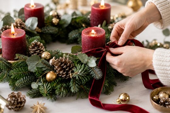 Decoraci&oacute;n de una corona navide&ntilde;a con velas y pi&ntilde;as en un ambiente festivo