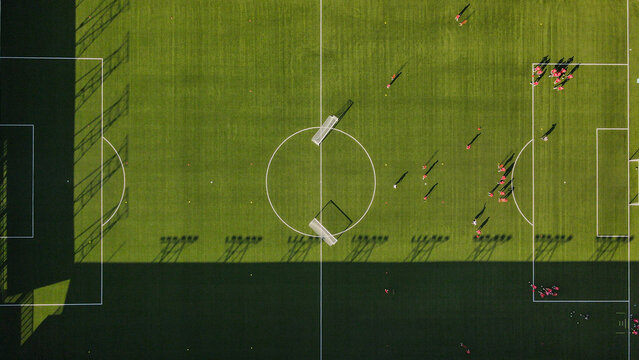 Aerial view of the soccer field on the roof of Stadion Shopping Center with players in red jerseys practicing on the green turf in Beograd, Grad Beograd, Serbia.