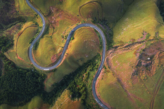 Aerial view of Long Tom Pass winding through the lush green hills and grassy slopes of the landscape in Ehlanzeni District Municipality, Mpumalanga, South Africa.