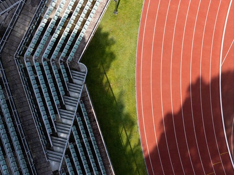 Aerial view of a stadium featuring a vibrant red running track and rows of green spectator seating, Gdansk, Poland.