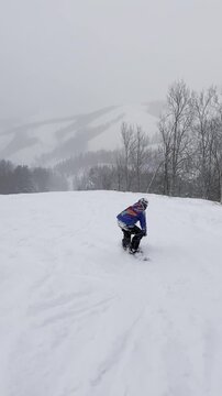 Video of a snowboarder riding down a slope. Live footage of a snowboarder on a snow-covered run. A calm descent.
