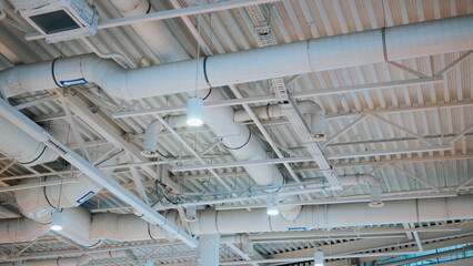 The ceiling features multiple ventilation ducts and lights arranged in a grid pattern. The setting...