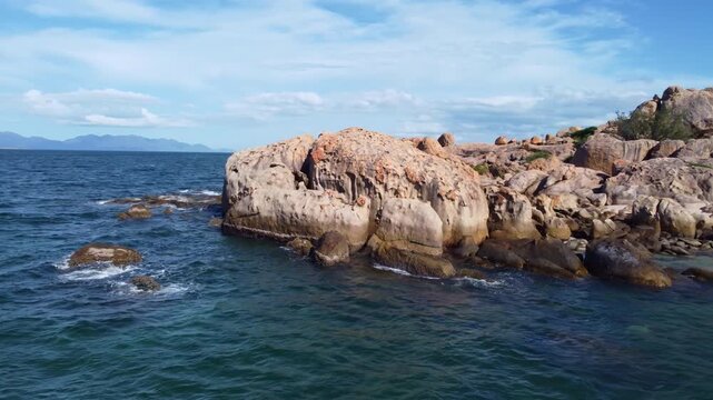 4K aerial drone 360 degree orbit shot of a rock in turquoise ocean water near Bowen, Queensland