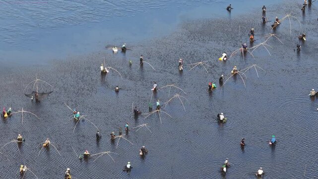 Drone video capturing a high altitude perspective of the bustling Tra Loc wetland lake filled with community fishers, valuable for travel documentaries and folklore reporting.