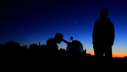 Amateur astronomers observing stars, planets, Moon and other celestial objects with a telescope in nature. © astrosystem