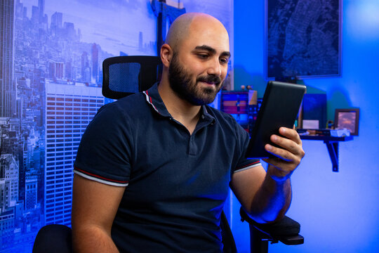 A man holding a Ebook reader. A man reading a book from an ebook reader. Reading a book on an ebook reader