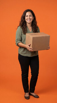 Latina woman holding cardboard box delivering package for shipping on orange studio background