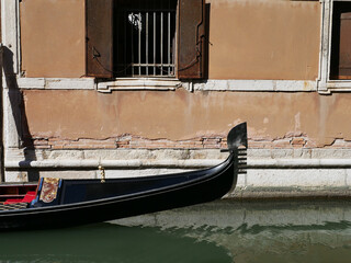 close up of a still venetian gondola boat on a canal in Venezia (Venice), Italy,  in front of a building © Isabella