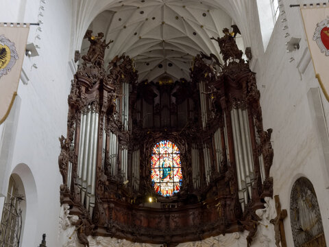 Church interior with a large organ and stained glass in a historical building