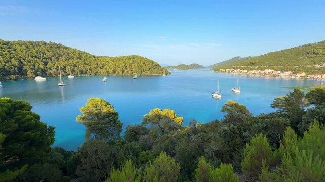 Panoramic view of Polace village on Mljet Island Croatia overlooking the Adriatic Sea. Peaceful Mediterranean coastal destination with anchored sailboats.