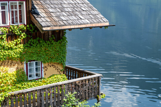 Hallstatt old traditional Wooden House with Wooden Balcony in Alpine Village rural landscape. Hallstatt Austria lake water nature. Ivy plant wall