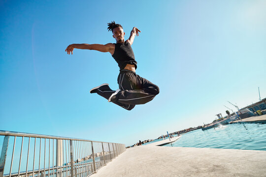 Man jumping in mid air against blue sky