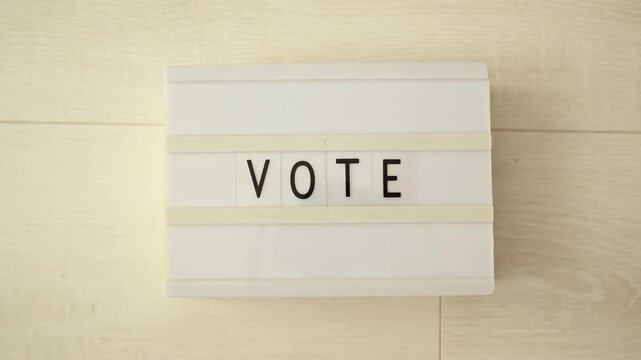 Close-up of a message board with the word vote, elections and democracy, stop motion