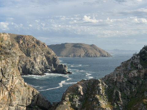 view from cliff to rocky mountains of Baja shore