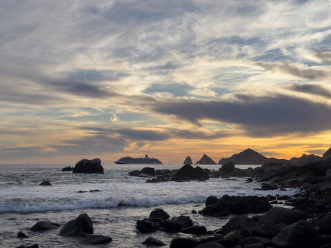 seascape of cruise ship sailing by famous arch in cabo san lucas
