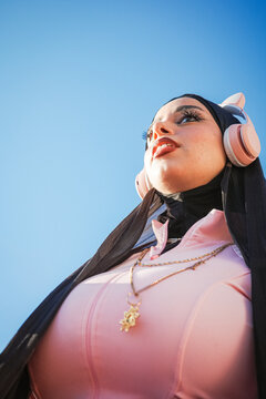 Woman with cat ear headphones gazing at clear blue sky
