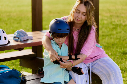 Mother Fastening Protective Gear for Young Son