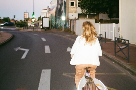 Cyclist riding through quiet suburban street at dusk