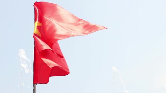 Red flag with a yellow star flutters in the wind, slow motion. Flag of Vietnam.
