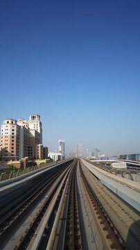 DUBAI, UAE - AUGUST 29, 2026: Dubai Metro train travels along an elevated track past Kempinski hotel toward the Dubai skyline in UAE during daytime