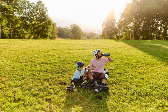 Father and Son Resting During Roller Skating