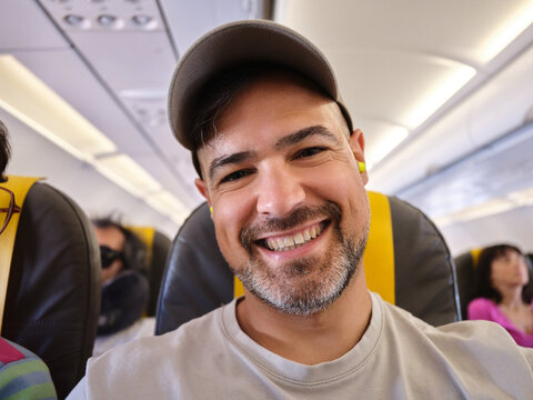 Man taking selfie in airplane during travel