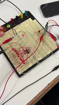 Engineer Prototyping Simple LED Circuit with Jumper Wires on Solderless Breadboard