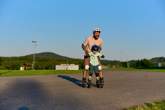 Father Supporting Son While Learning to Roller Skate
