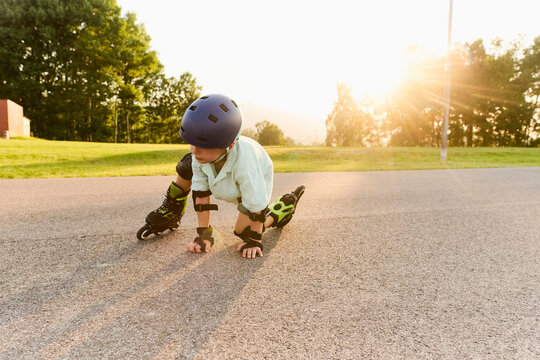 Young Boy Falling While Learning Roller Skating
