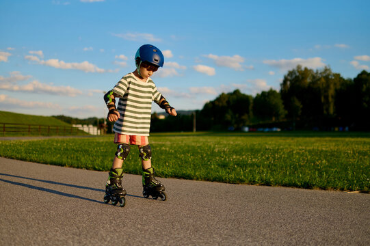 Little boy roller skating on a park pathway