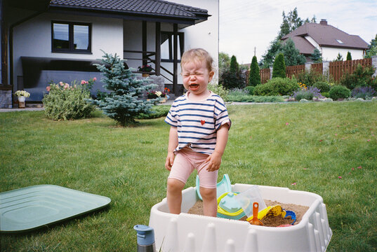 Little girl crying in a playground sandbox